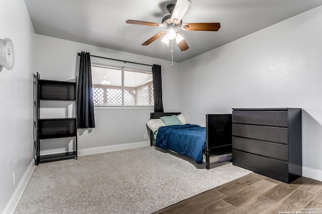 bedroom with wood finished floors, a ceiling fan, and baseboards