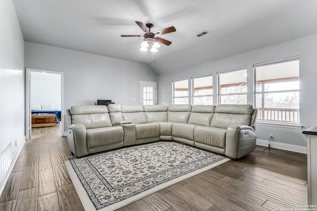 living room with lofted ceiling, visible vents, ceiling fan, wood finished floors, and baseboards