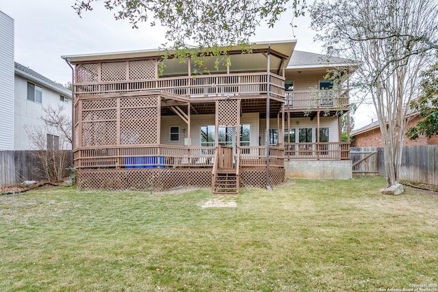 rear view of house with a fenced backyard, a deck, and a lawn