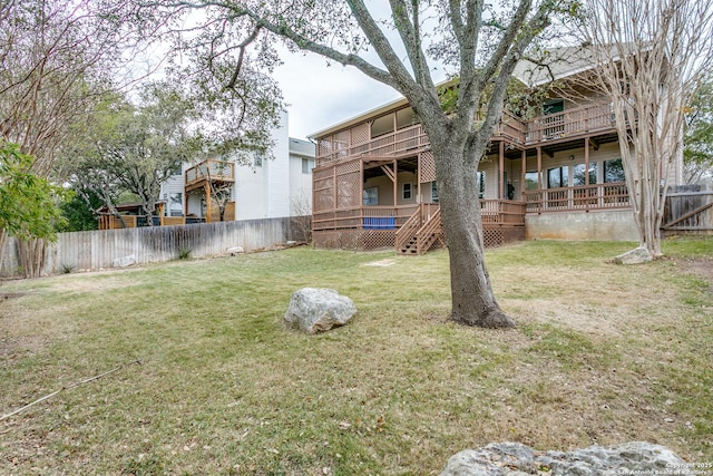 view of yard with a balcony, a fenced backyard, and a deck