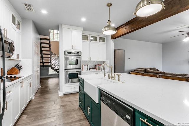 kitchen featuring open floor plan, appliances with stainless steel finishes, visible vents, and white cabinets