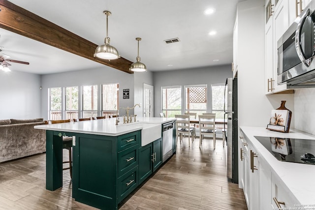 kitchen featuring visible vents, white cabinets, appliances with stainless steel finishes, open floor plan, and green cabinets