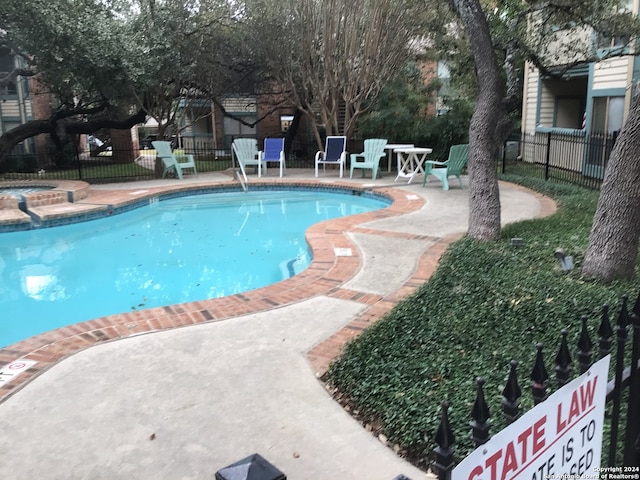 view of swimming pool with a patio and a hot tub