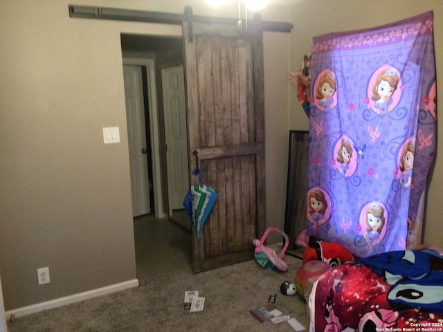 bedroom with carpet flooring and a barn door