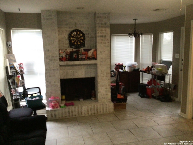 tiled living room featuring a fireplace and a chandelier