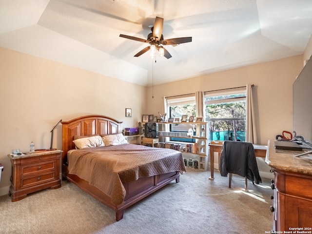 carpeted bedroom featuring a tray ceiling, ceiling fan, and lofted ceiling