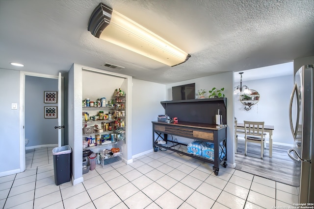 misc room featuring light tile patterned floors and a textured ceiling