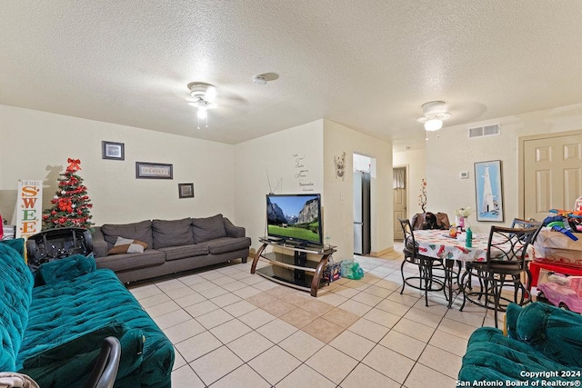 living room with a textured ceiling, ceiling fan, and light tile patterned flooring