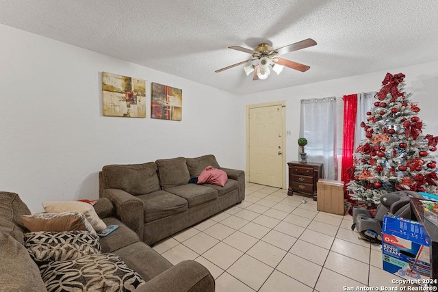 living room featuring ceiling fan, light tile patterned floors, and a textured ceiling