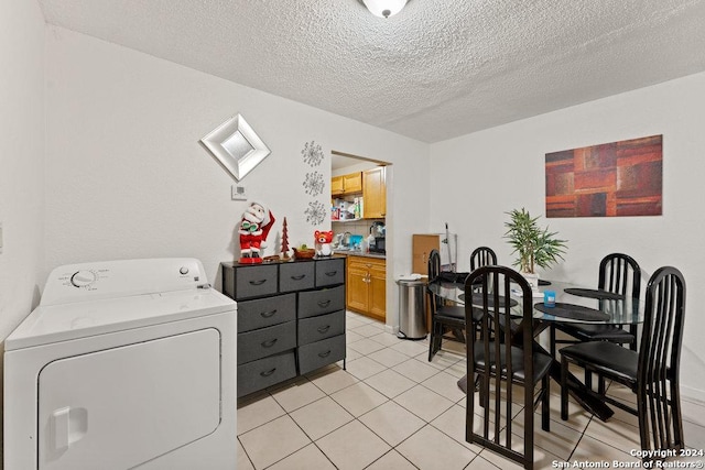 laundry area featuring light tile patterned flooring, a textured ceiling, and washer / dryer