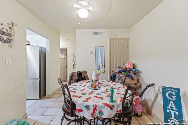 tiled dining room featuring ceiling fan and a textured ceiling