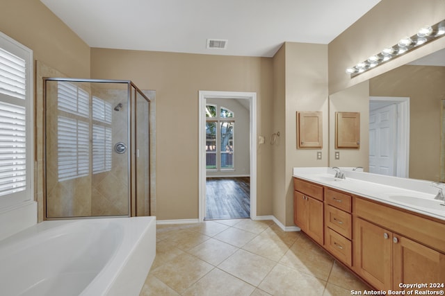 bathroom featuring tile patterned flooring, vanity, and plus walk in shower