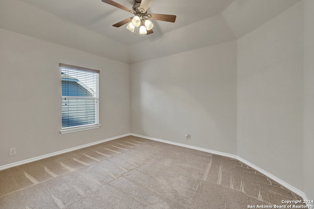 carpeted spare room with ceiling fan and vaulted ceiling