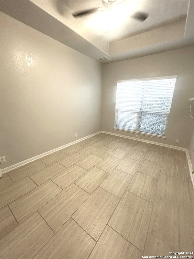 unfurnished room featuring a raised ceiling