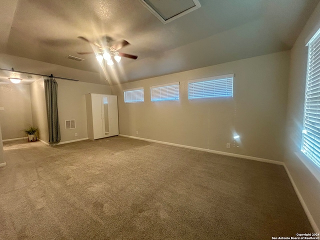 carpeted empty room with ceiling fan and lofted ceiling