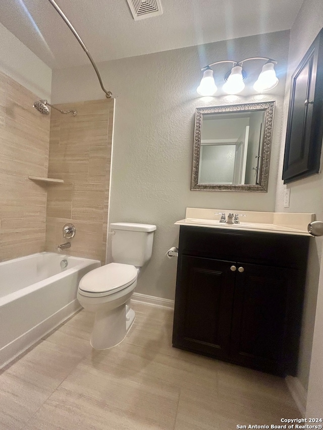 full bathroom with tiled shower / bath combo, toilet, and vanity