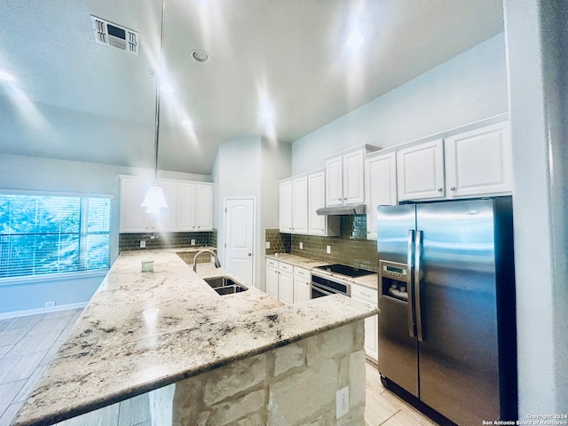 kitchen with sink, backsplash, stainless steel fridge, decorative light fixtures, and white cabinets