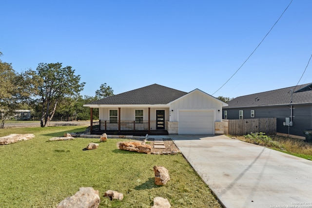 view of front of house with a garage, covered porch, and a front lawn