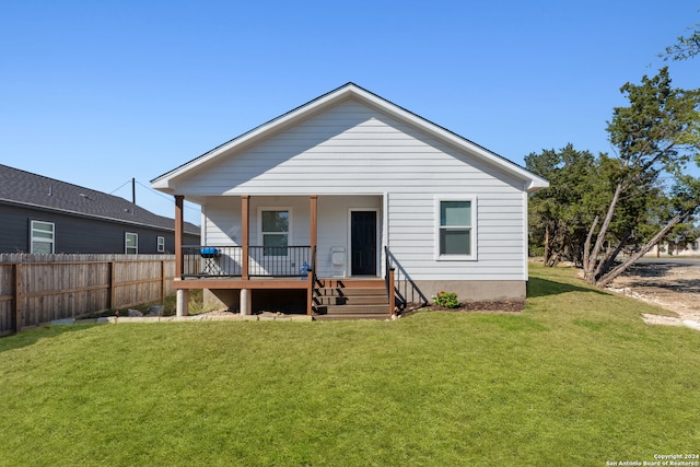 back of house with a yard and covered porch