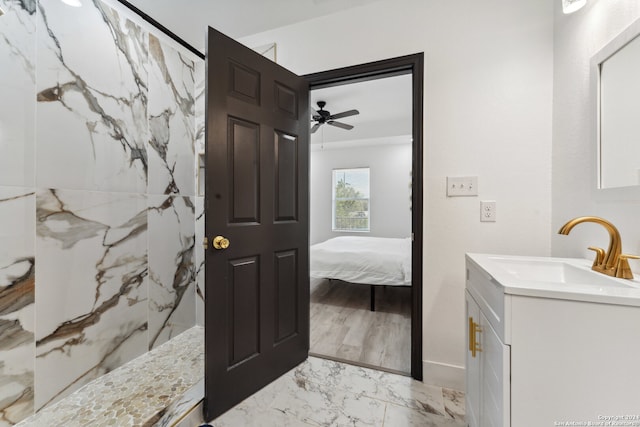 bathroom with hardwood / wood-style floors, vanity, ceiling fan, and a tile shower