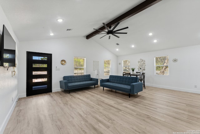 living room featuring vaulted ceiling with beams, a wealth of natural light, and light hardwood / wood-style flooring