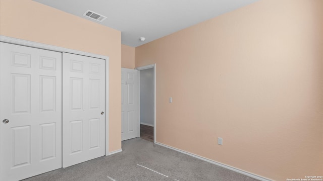 unfurnished bedroom with a closet and light colored carpet