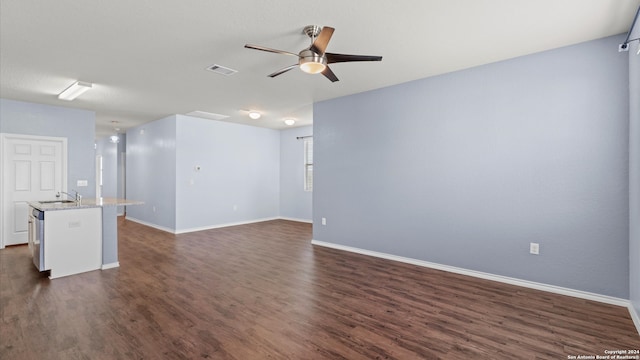 unfurnished living room featuring dark hardwood / wood-style flooring, ceiling fan, and sink