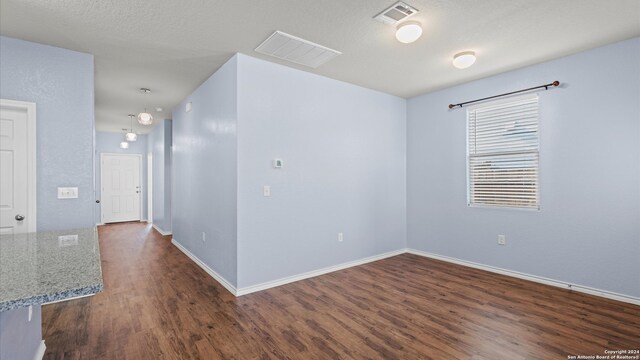 unfurnished room featuring a textured ceiling and dark wood-type flooring