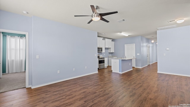 unfurnished living room with ceiling fan, sink, and dark wood-type flooring