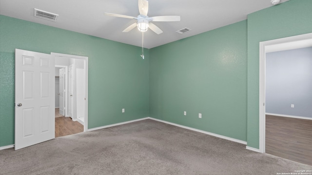 empty room featuring ceiling fan and light colored carpet