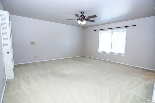 spare room featuring ceiling fan and light carpet