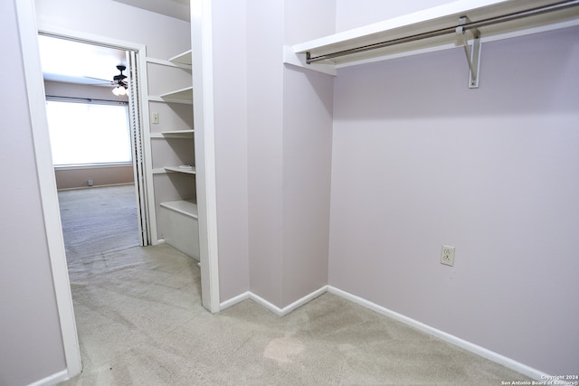 spacious closet featuring light colored carpet and ceiling fan