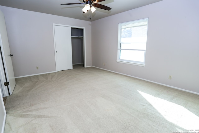 unfurnished bedroom with ceiling fan, a closet, and light colored carpet