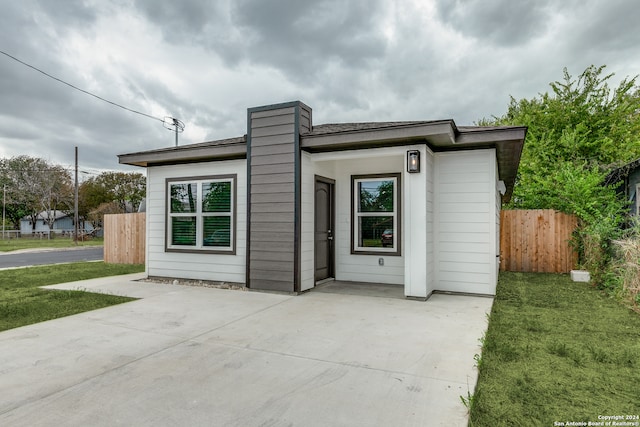 exterior space featuring a patio area and a front lawn