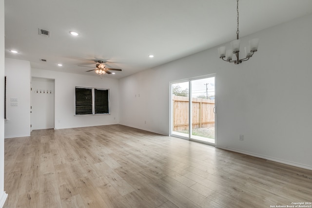 unfurnished living room with light hardwood / wood-style flooring and ceiling fan with notable chandelier