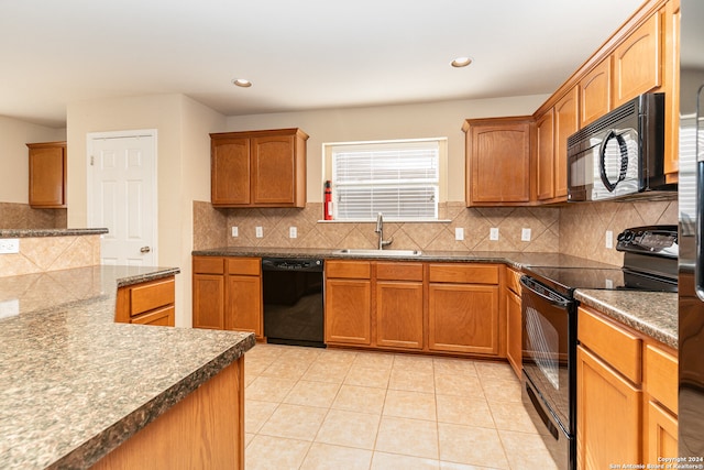 kitchen with light tile patterned flooring, sink, tasteful backsplash, and black appliances