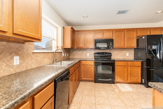 kitchen with backsplash, sink, light tile patterned flooring, and black appliances