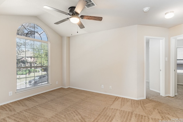 empty room with ceiling fan, light colored carpet, and vaulted ceiling