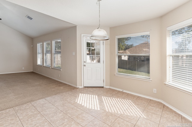 unfurnished dining area featuring plenty of natural light and light colored carpet