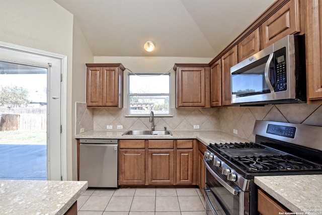 kitchen featuring backsplash, sink, stainless steel appliances, and plenty of natural light