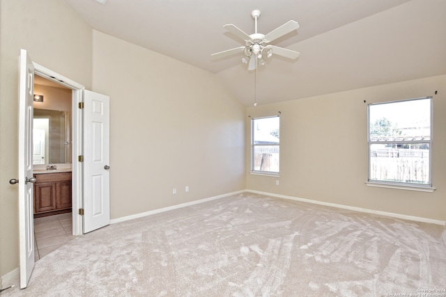 carpeted spare room with vaulted ceiling, ceiling fan, and sink