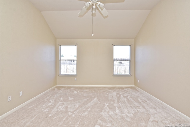 empty room featuring light carpet, plenty of natural light, and vaulted ceiling