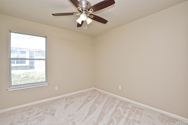 carpeted empty room with ceiling fan and a wealth of natural light