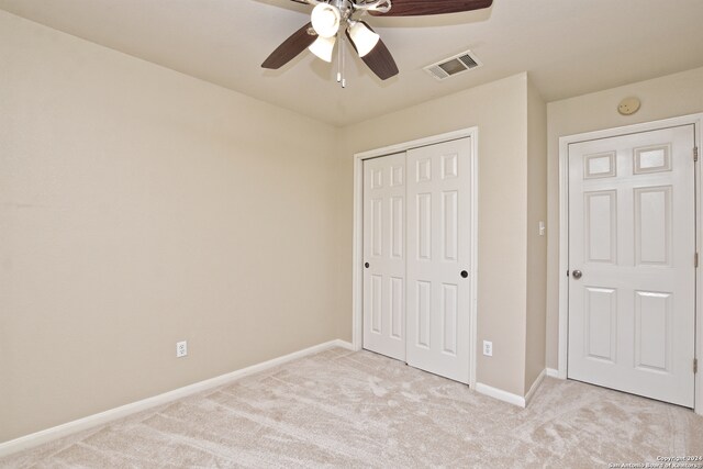 unfurnished bedroom with ceiling fan, a closet, and light colored carpet