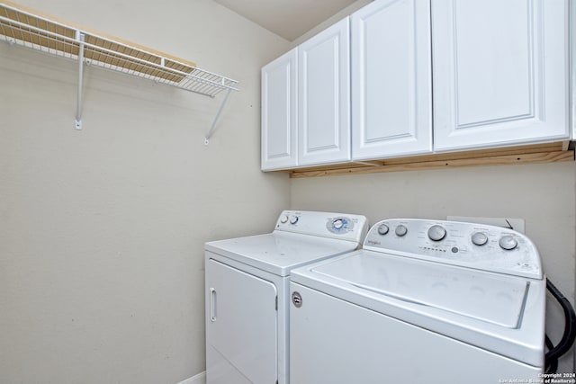 laundry room with washer and clothes dryer and cabinets