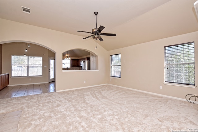 empty room with light colored carpet, a healthy amount of sunlight, and lofted ceiling