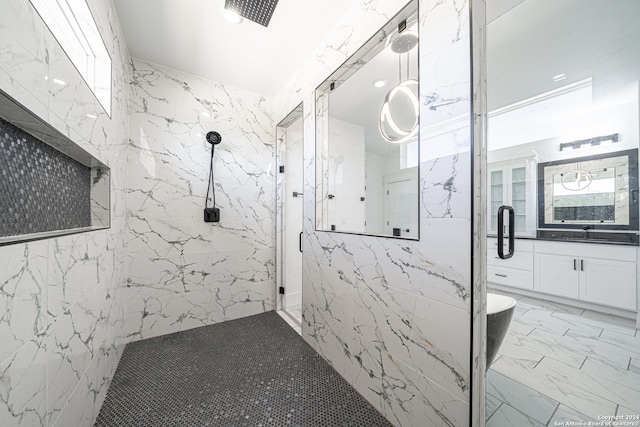 bathroom featuring vanity, a shower with shower door, and tile walls