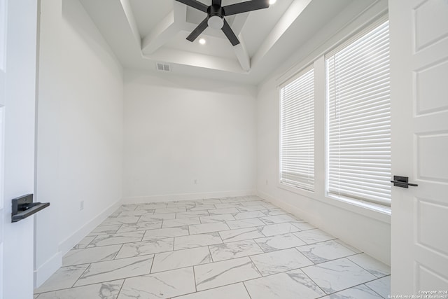 spare room featuring a tray ceiling and ceiling fan