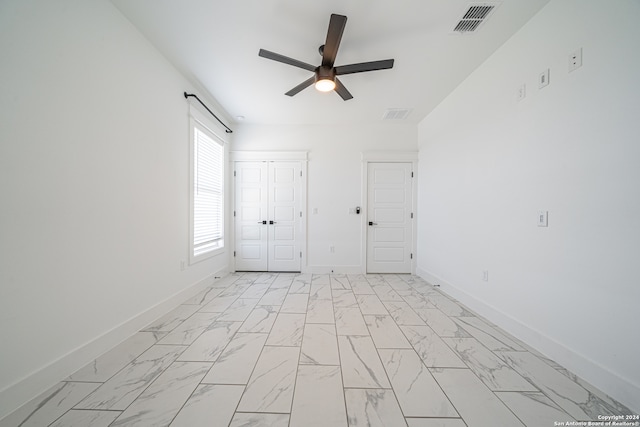 unfurnished bedroom with ceiling fan and a closet