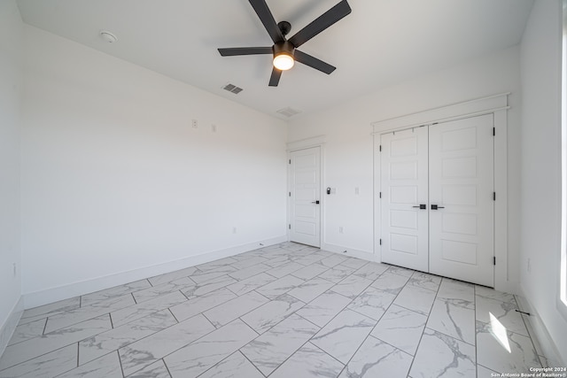 unfurnished bedroom with ceiling fan and a closet